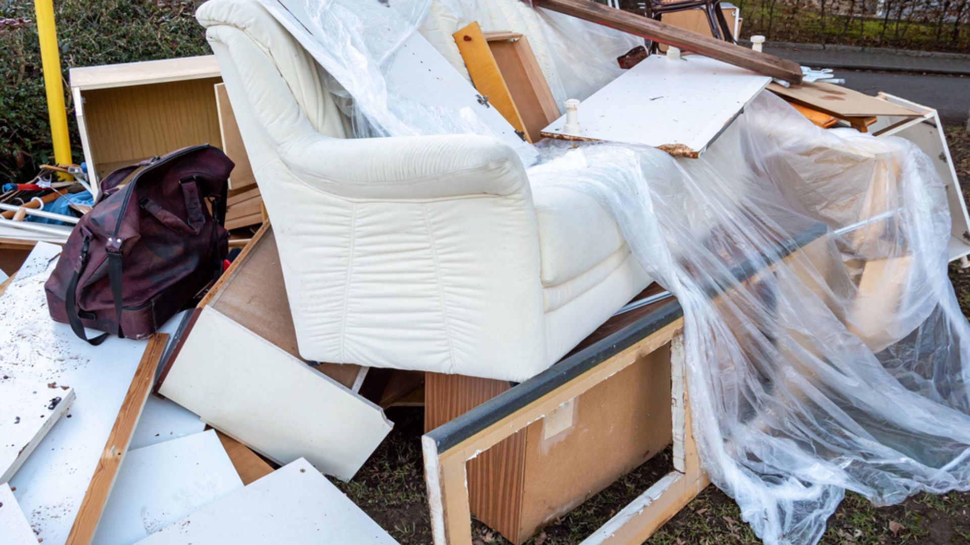 Déchets encombrants déposés en bordure de rue à Mulhouse, comprenant un fauteuil, des meubles démontés et des sacs, illustrant la gestion des déchets volumineux.